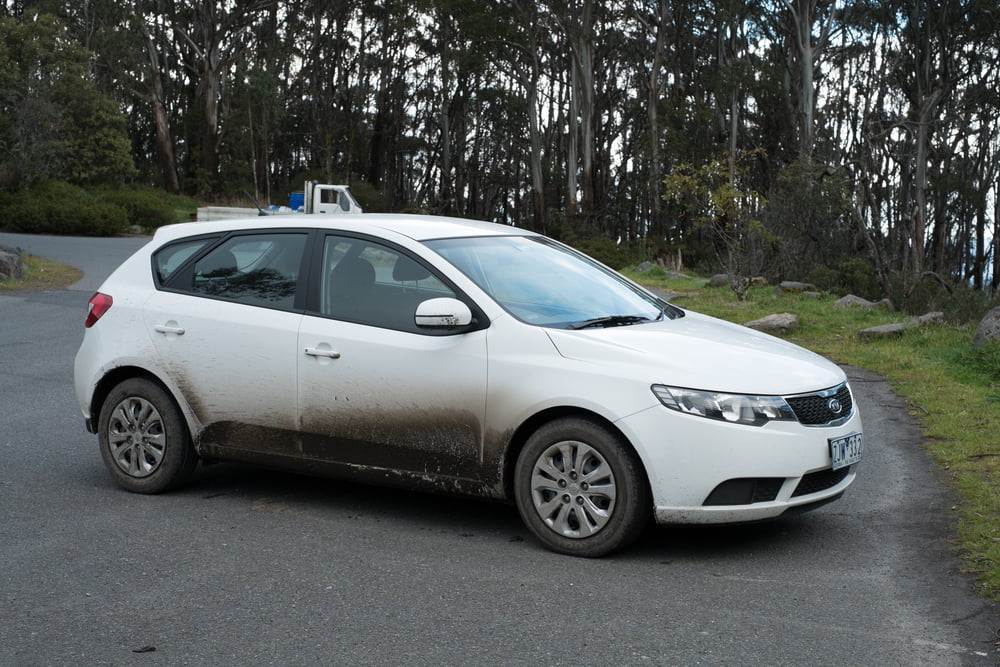 A white rental car with mud streaks