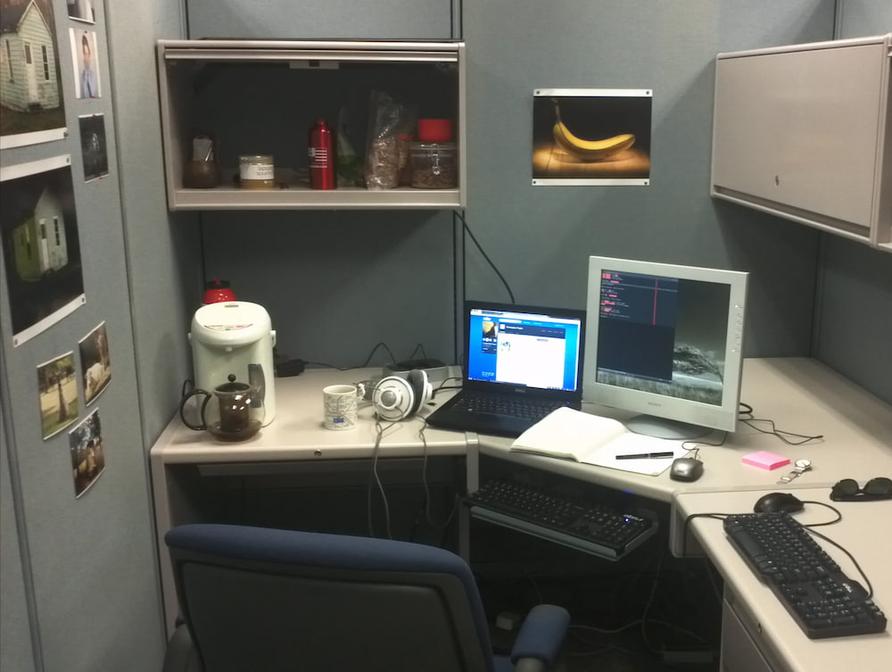 Office cubicle with computer monitor and laptop
